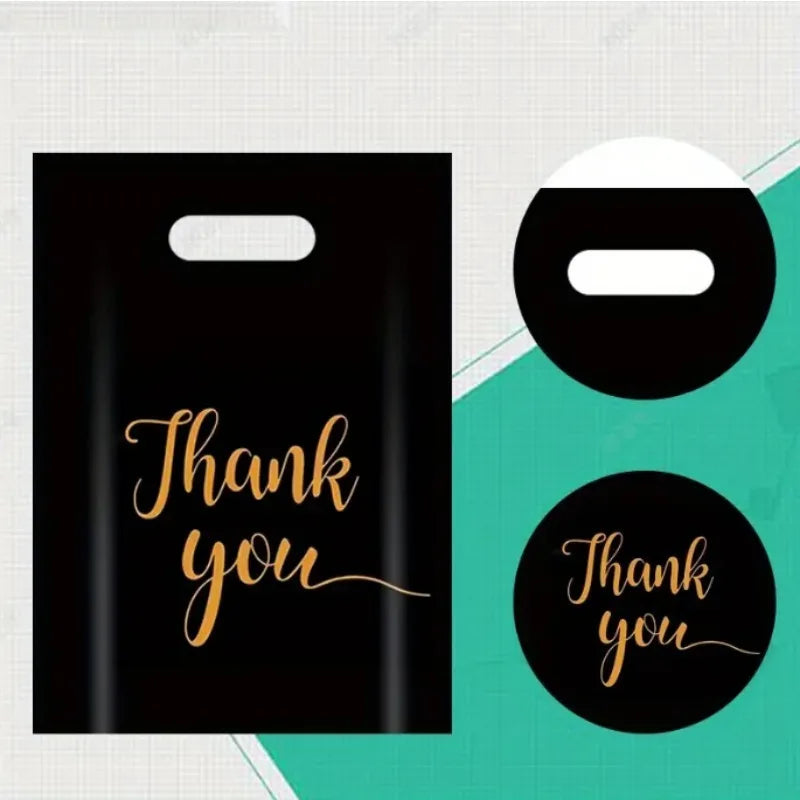 Black gift bags with gold script text Thank you displayed against a light background.