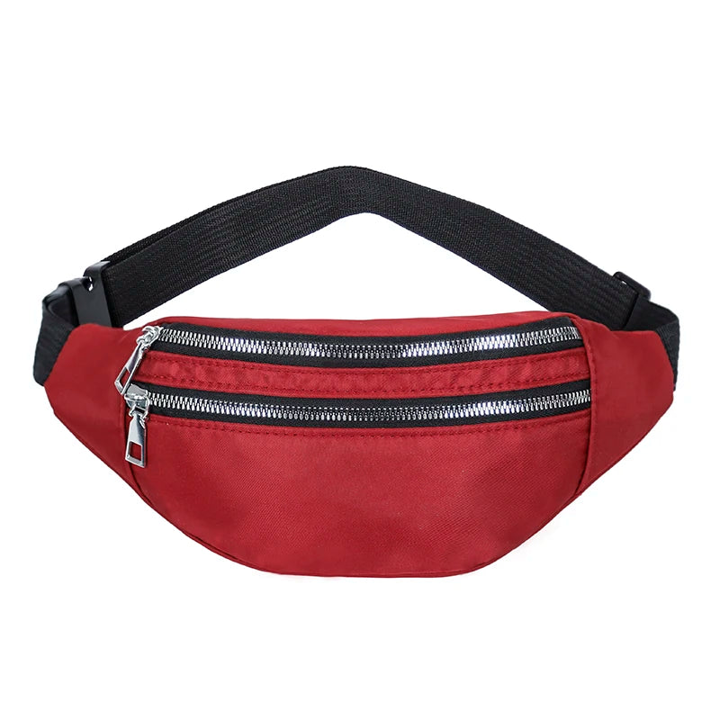 A red nylon crossbody sling bag with a black adjustable strap and a silver zipper.