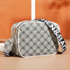 A beige and black patterned fashion crossbody shoulder bag with a white trim and black strap.