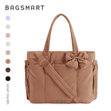A tan canvas tote bag with multiple pockets and a bow detail shown against a white background.