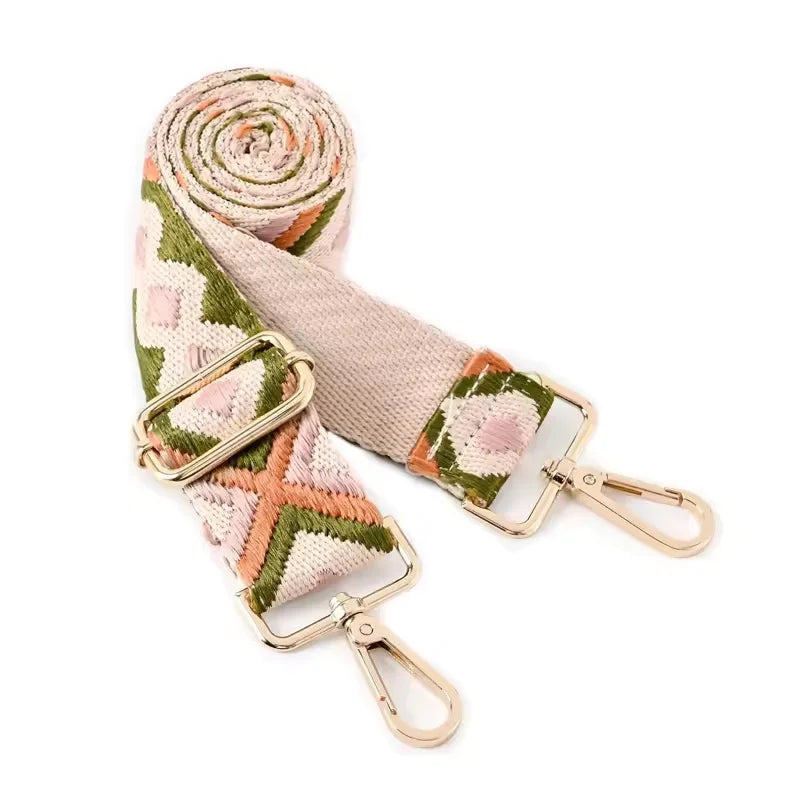 A roll of beige and green patterned nylon strap for an adjustable crossbody bag.