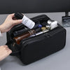A black PU leather travel toiletry bag is open, showing various beauty products and a perfume bottle.