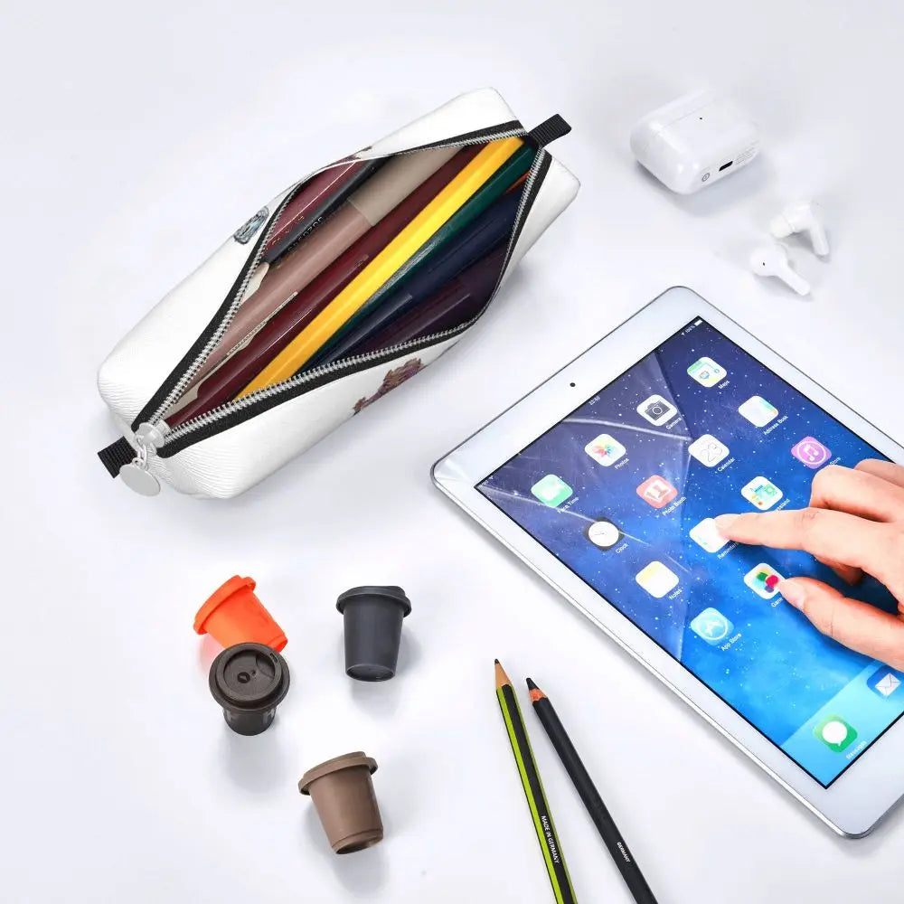 An elegant leather pencil case is shown open, displaying various colored pencils and pens on a white background.