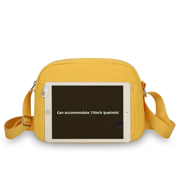 A yellow nylon crossbody bag with a clear window showing a 7.9-inch iPad inside.