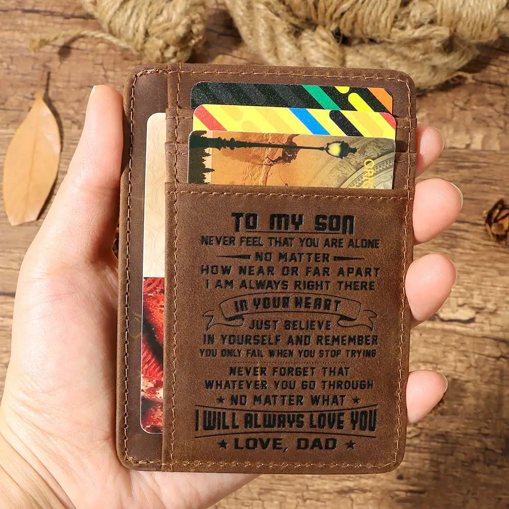 Portefeuille en cuir marron gravé 'À mon fils' avec une photo, tenu dans la main d'une personne.