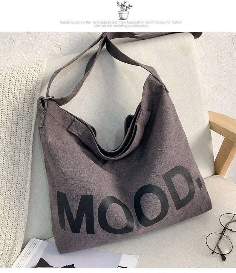 A gray canvas tote bag featuring the word MOOD printed in black text, displayed on a light surface.