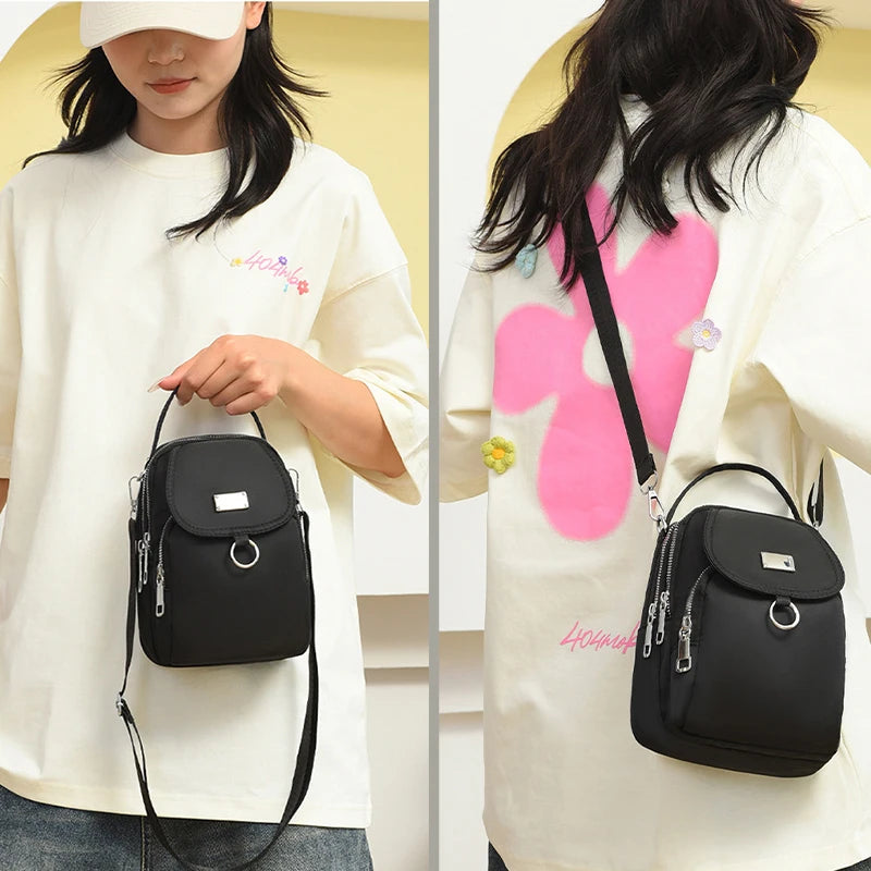 Sac bandoulière floral noir porté par une femme sur fond clair.