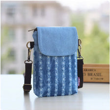 A light blue denim mini messenger bag with a flap and strap resting on a white surface.