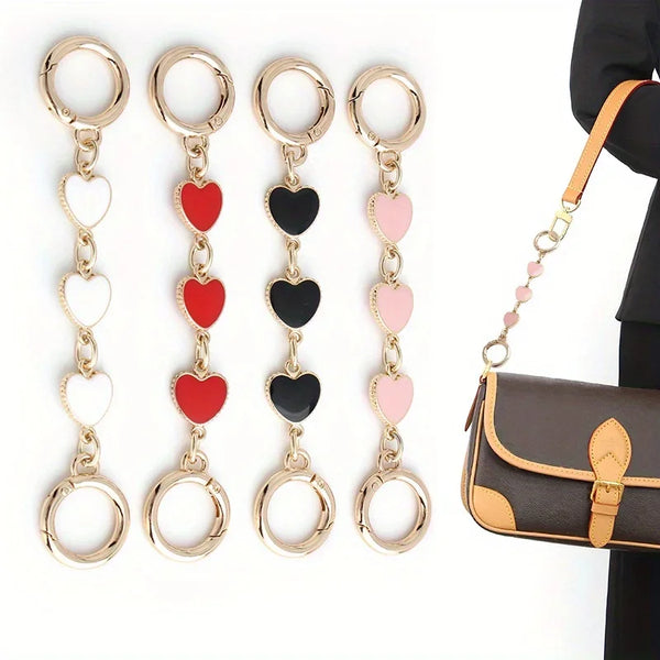 Five gold-toned heart pendant chains with black and pink beads and jump rings displayed against a white background.