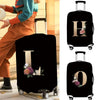 Black luggage with gold lettering and floral accents shown on a light surface.