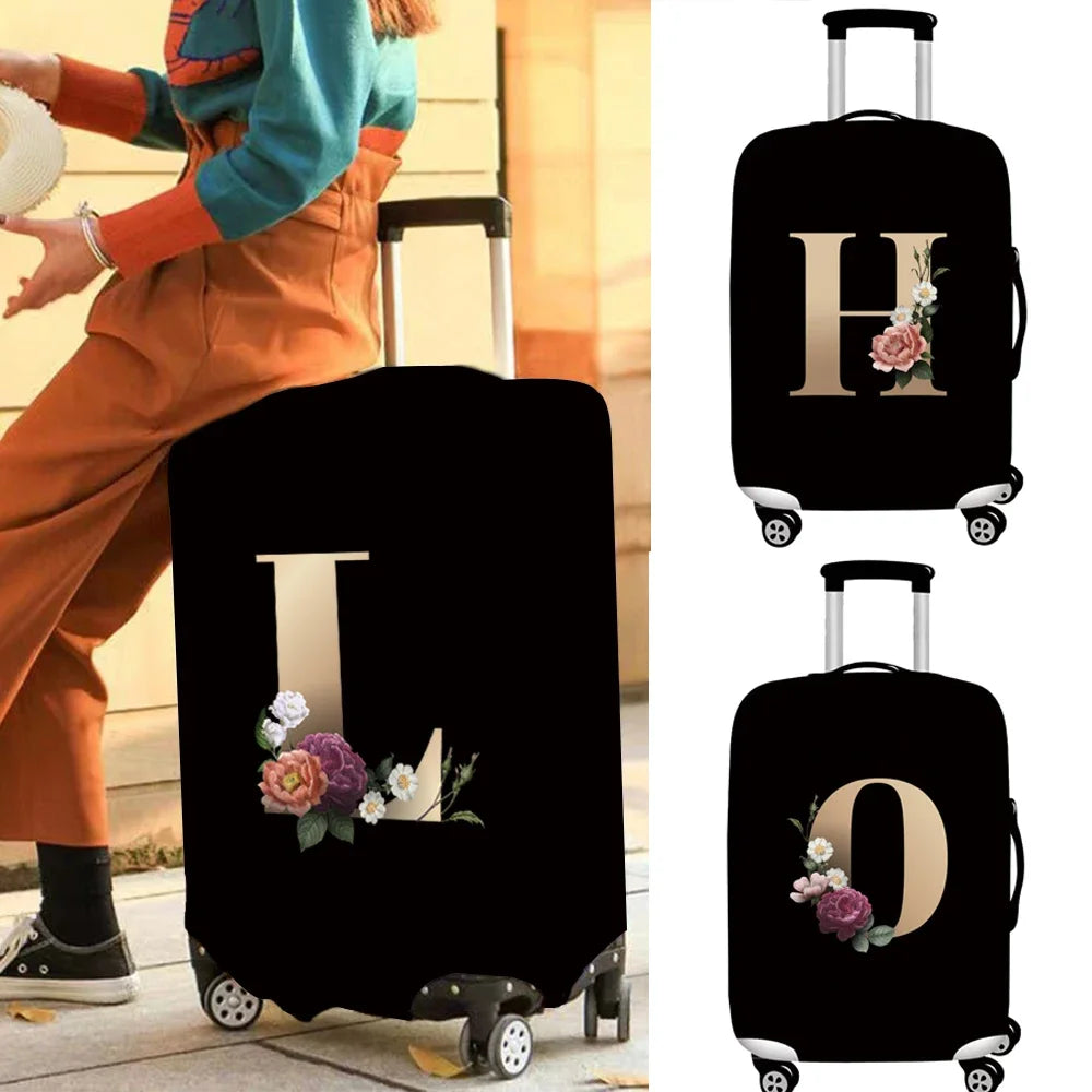Black luggage with gold lettering and floral accents shown on a light surface.