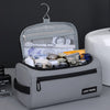 A light gray toiletry bag with a zippered compartment and a hanging loop, containing various grooming tools.