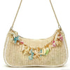 A beige straw shoulder bag adorned with colorful sea star and shell charms.