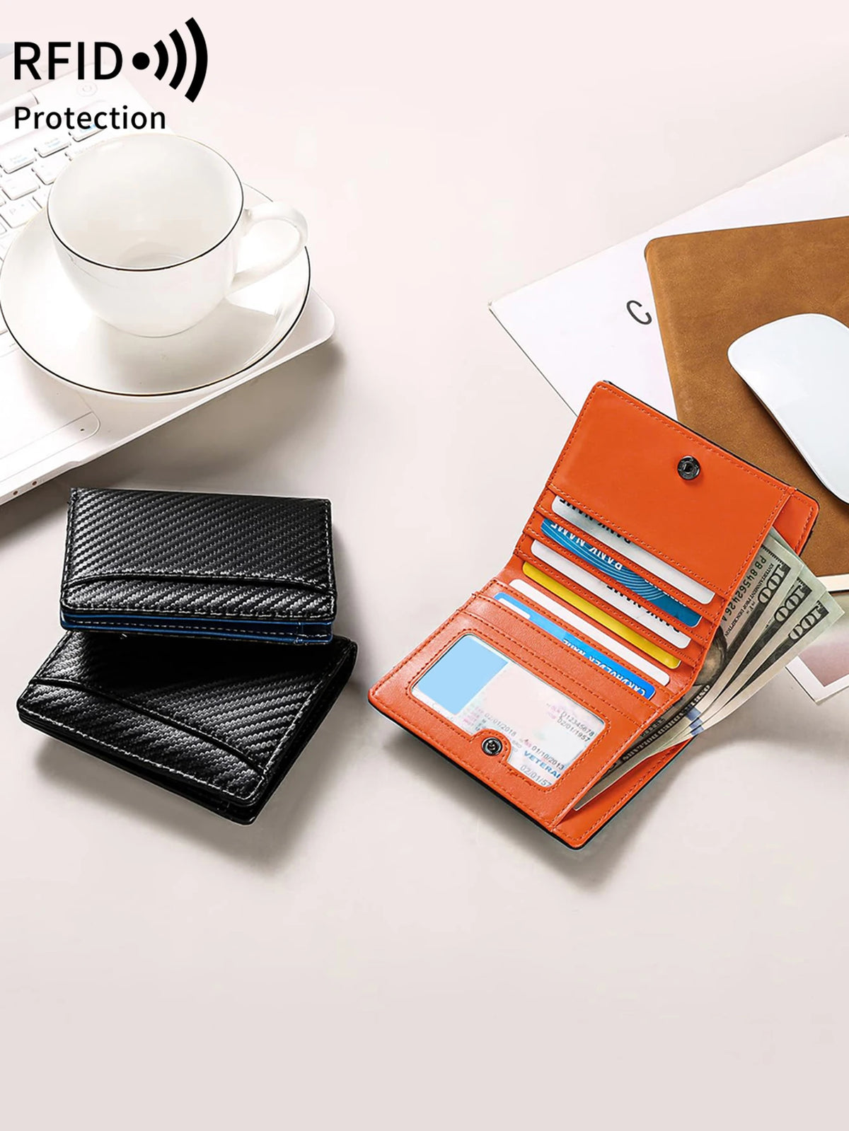 An orange RFID-blocking bi-fold wallet with a carbon fiber finish is shown next to a black leather wallet and a white cup.