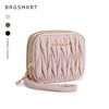 A light pink quilted mini coin purse and card holder wallet with a gold chain detail.