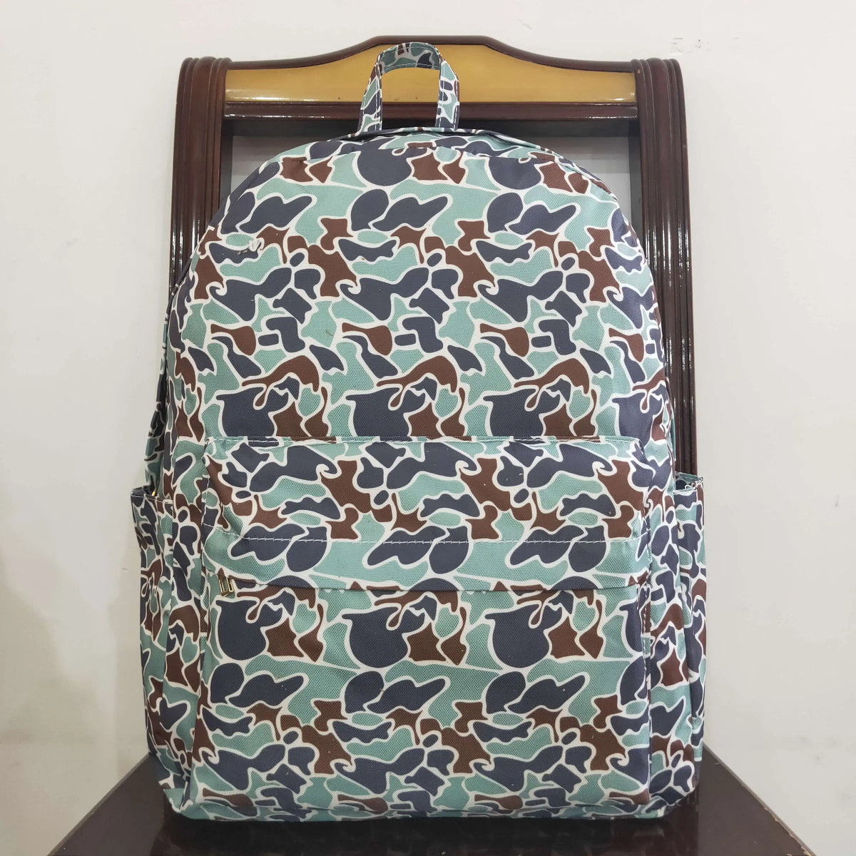A patterned backpack featuring a camouflage design of brown and blue animal prints.