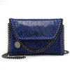 A dark blue velvet flap crossbody bag with a silver chain strap.