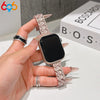 A hand is holding a black Apple Watch with a sparkling crystal fishscale metal band.