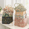 A stack of quilted fabric storage baskets in various floral patterns and colors on a white surface.