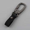 A close-up view of a genuine leather keyring keychain with a metal clasp and black leather strap.