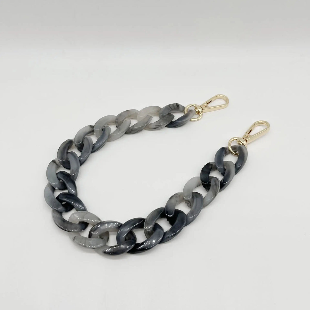 A silver and black multicolor acrylic chain bracelet laid flat against a white background.