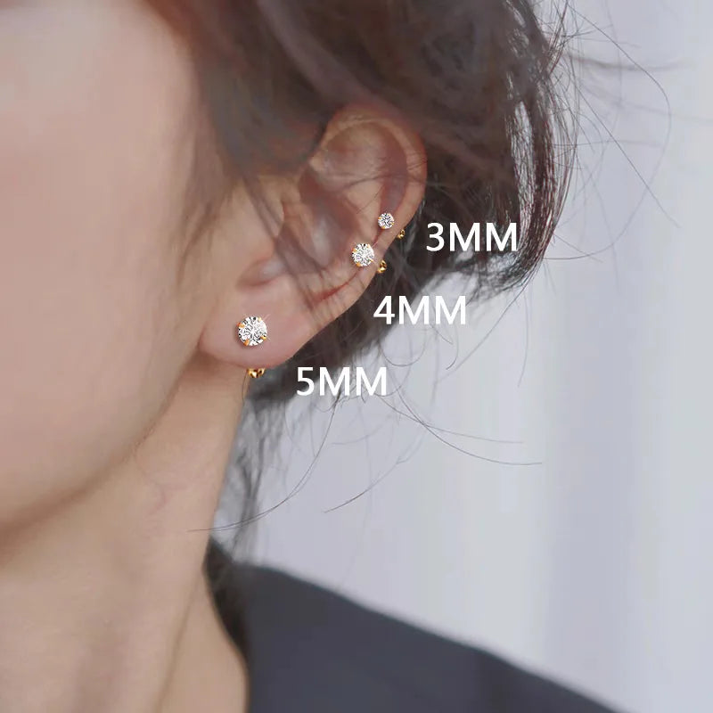 A close-up of a person's ear showing a set of stainless steel stud earrings in various sizes, including 3mm, 4mm, and 5mm.