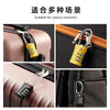 Yellow combination lock attached to a luggage zipper on a pink and black bag.