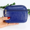 A hand holds a dark blue PU leather mini wallet with a silver keychain against a white background.