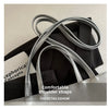 Silver leather shoulder straps displayed on a black bag in a product show context.