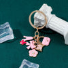 Papillon de cœur or et rose, clé USB suspendue sur une base en pilier argenté.