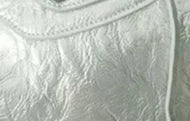 Close-up of a light gray soft PU leather shoulder tote bag with stitched detailing.