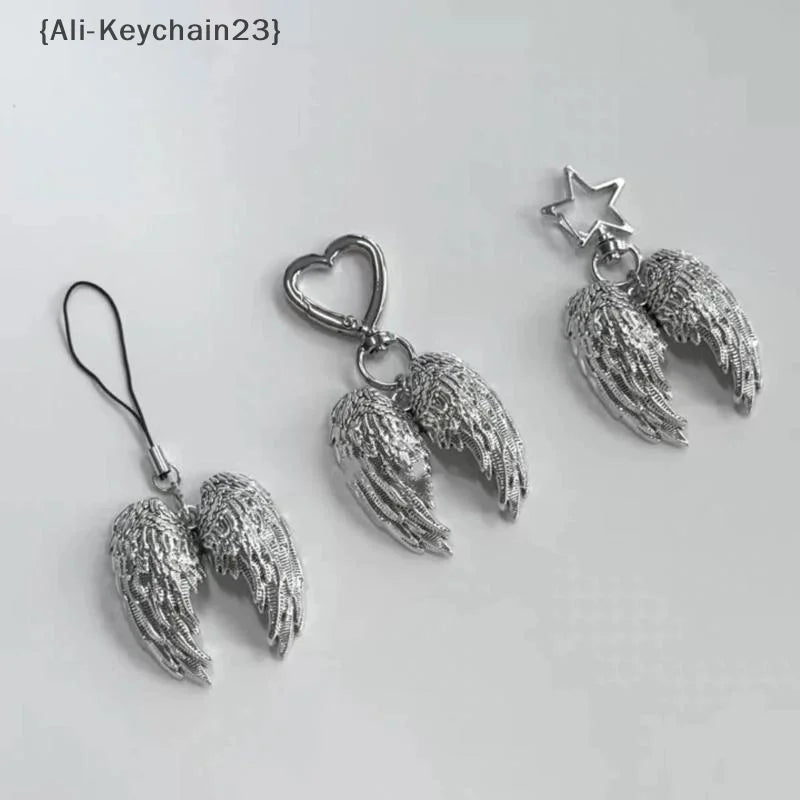 Silver metal angel wing keychain charm with a heart and star design
