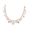 A delicate gold bohemian layered bag chain featuring pearls and starfish charms.