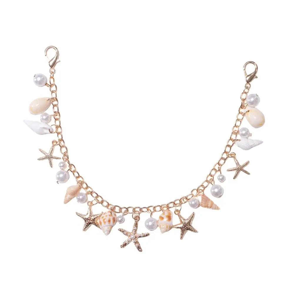 A delicate gold bohemian layered bag chain featuring pearls and starfish charms.