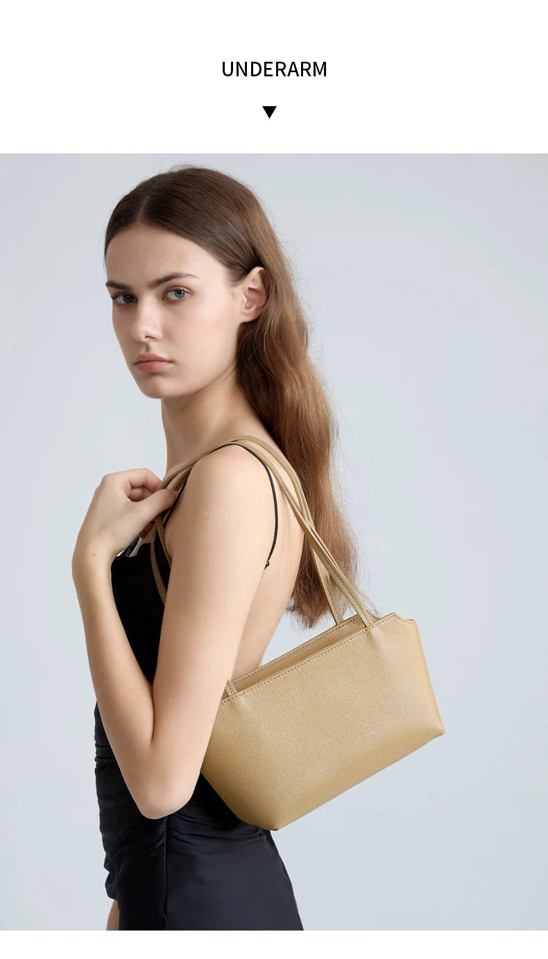 A model holds a tan leather mini shoulder bag with adjustable straps against a light gray background.