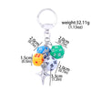 Silver keychain charm featuring five colored dice: blue, yellow, green, white, and black.