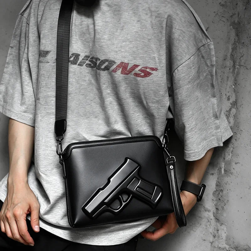 A person holds a black embossed crossbody clutch bag featuring a replica firearm design.