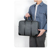 A person holds a dark gray executive PU leather laptop briefcase with a shoulder strap.