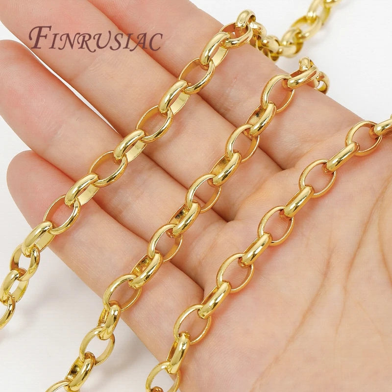 A hand holds several strands of gold-colored, linked jewelry chains for crafting.