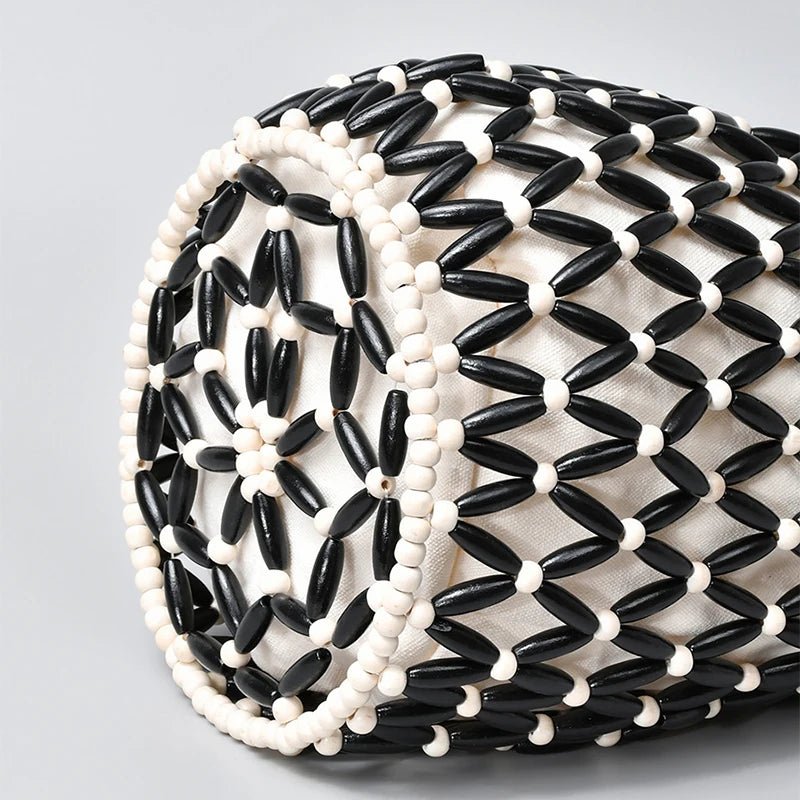 A close-up of an elegant beaded clutch bag featuring black and white seed beads.