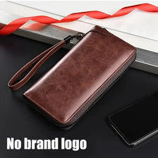 Portefeuille à fermeture éclair en cuir PU marron posé sur une surface sombre à côté d'un smartphone et d'un ruban rouge.