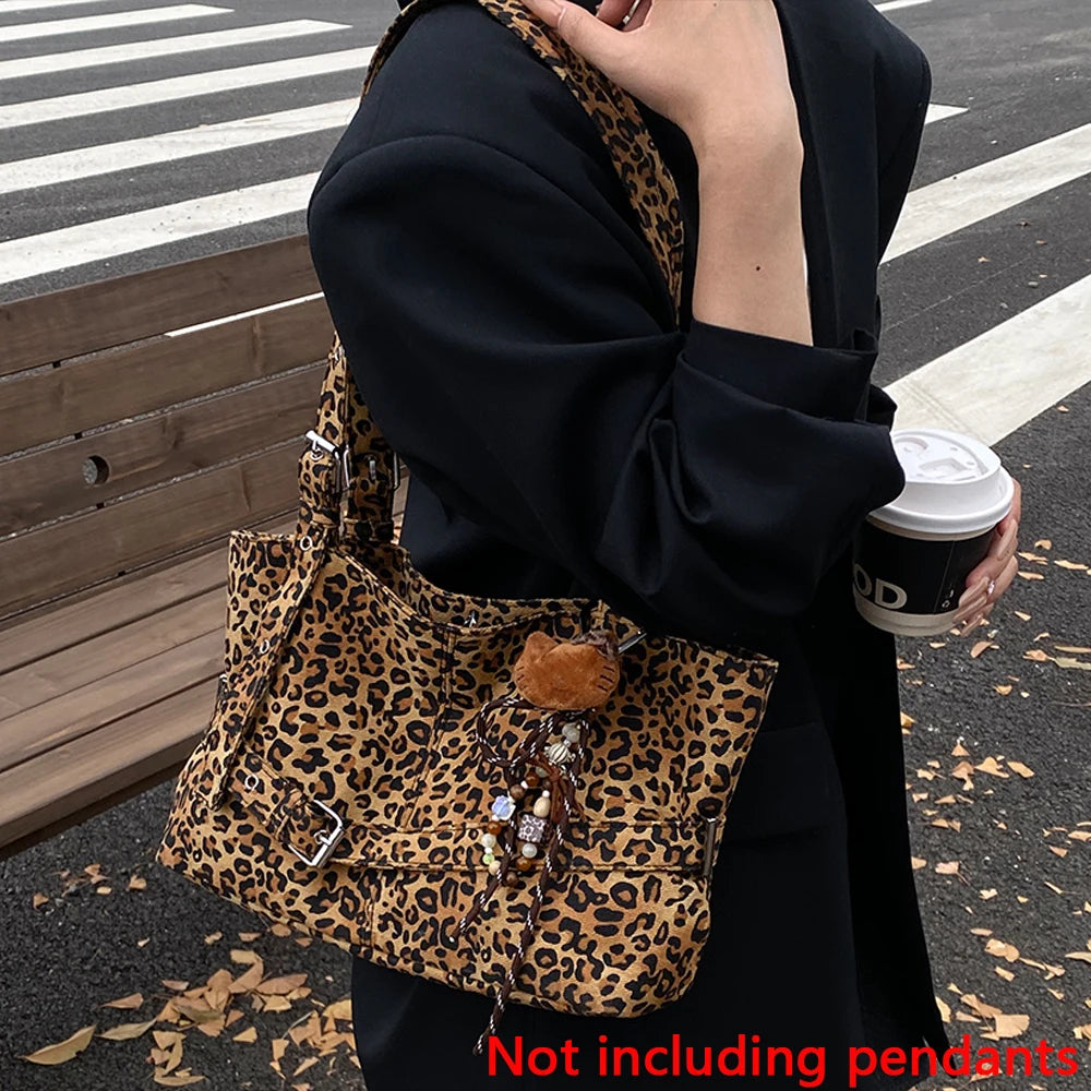 A person holds a leopard print casual tote bag in black and black clothing on an asphalt surface.