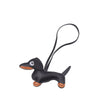 A black dachshund leather keychain charm with orange accents.