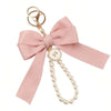 Llavero decorativo rosa con dije de corbata y perla.