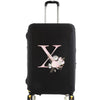 Black luggage with a silver handle featuring a large pink floral letter X design