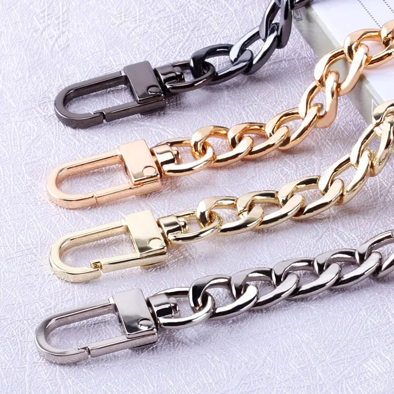 Gold and silver diamond-cut curb chain bag straps displayed on a light surface.