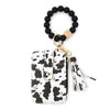 A black beaded tassel keychain wristlet with a gold accent and card holder.