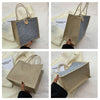 A beige linen tote bag with blue floral fabric and a leather closure is displayed against a white background.