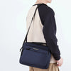 A navy blue professional waterproof men's business briefcase worn over a light colored shirt.