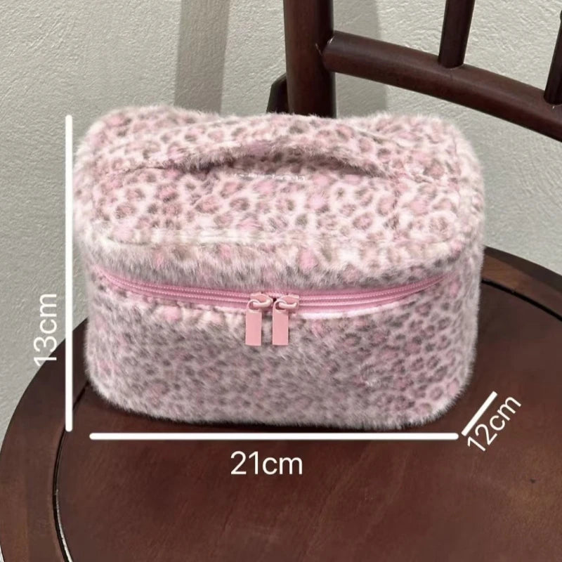 Bolsa de maquillaje para viajar con estampado de leopardo rosa y cierre de cremallera, mostrada junto a una regla para escala